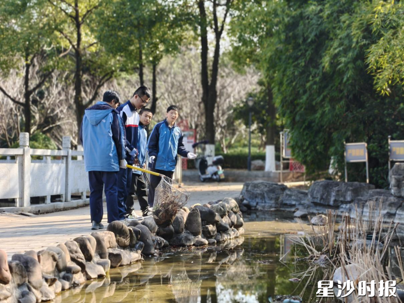 图为学生清理水池，打捞落叶与污泥。均为县实验中学供图
