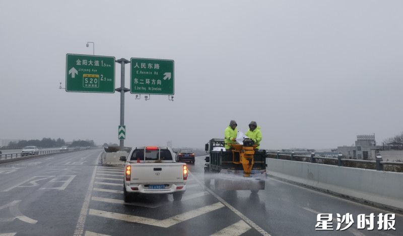黄花镇党员干部在辖区关键路段开展撒盐除雪作业，对积水、结冰路面进行清理。