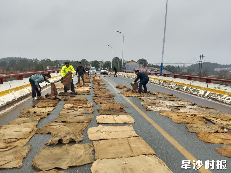 青山铺综合行政执法大队队员与镇政府、洪河村干部一道,对桥面铺设麻袋和撒盐作业,确保道路交通和人民群众出行安全。 县行政执法局供图