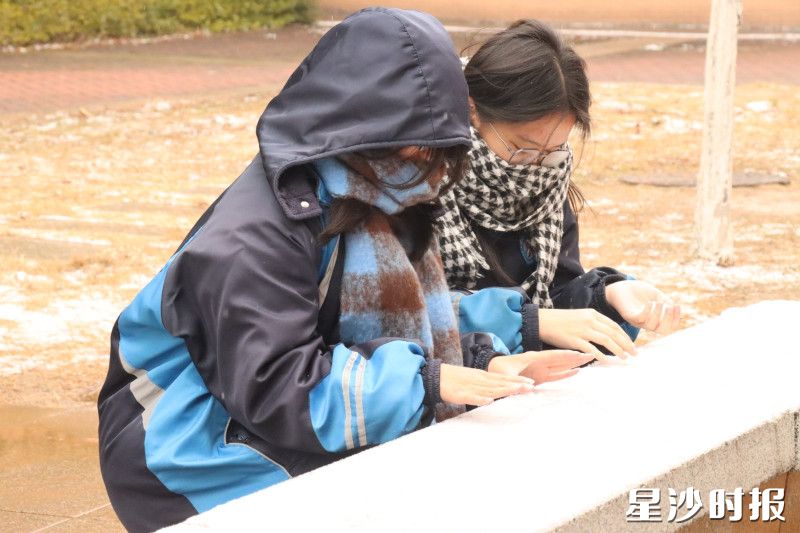 在长沙麓山国际昌济中学，两个女生凑在落满雪的石台上认真涂画。雪花落在她们的肩头，却一点也没打扰这份安静的陪伴。
