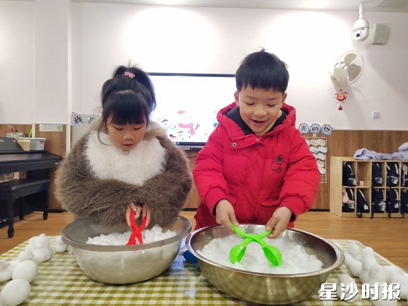 在㮾梨街道集美星宸幼儿园教室里暖融融的，两个小家伙守着装满雪的大盆，用小铲子认真地拨弄着，仿佛在挖着冬天独有的宝藏。