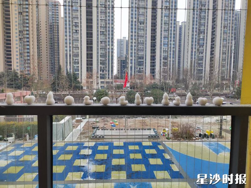 在㮾梨街道集美星宸幼儿园教学楼的栏杆上，学生捏的整整齐齐排着一排小雪团，有的圆滚滚，有的被捏成了小兔子的模样，像一群安静的小卫士守在窗边。