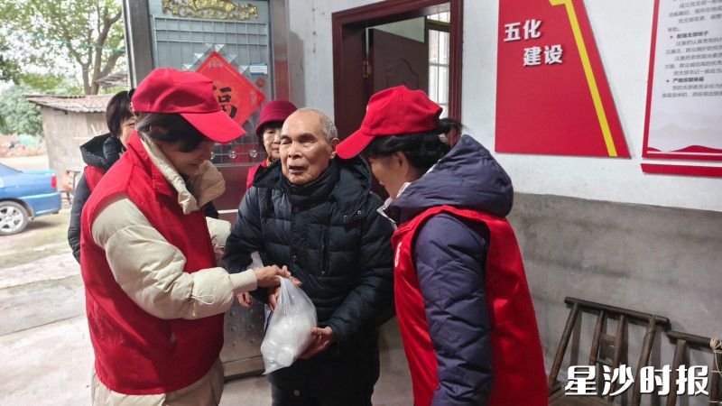 “老红书”志愿者服务队在汉爹家里送去冬日温暖。花园村供图