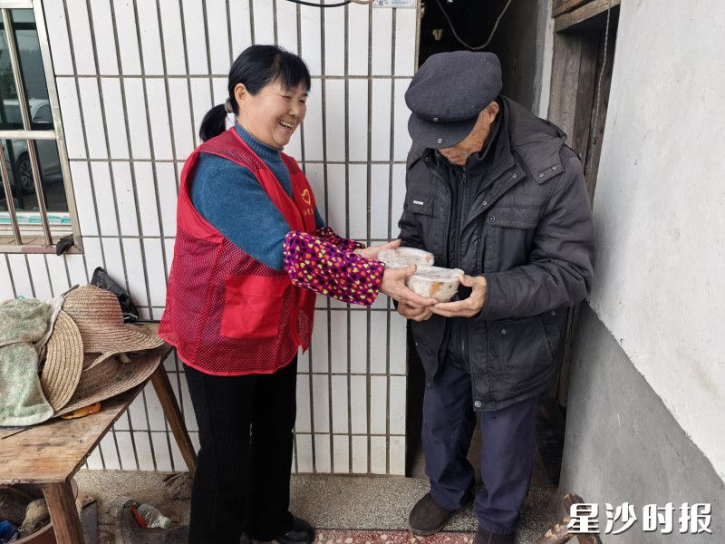 志愿者将满载心意的八宝饭送往孤寡老人家中。