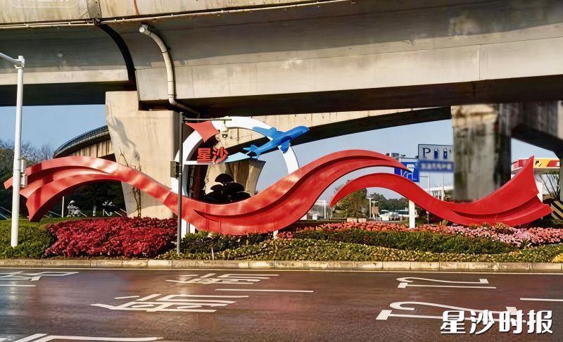 机场高架桥桥墩三角转盘处，红色喜庆飘带与蓝色飞机造型相映成趣，与周边绿意融为一体。长沙县城管局供图