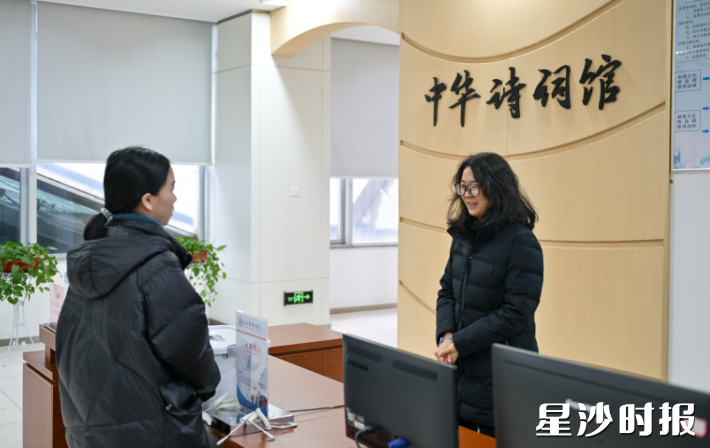 图书馆工作人员为读者解答问题。