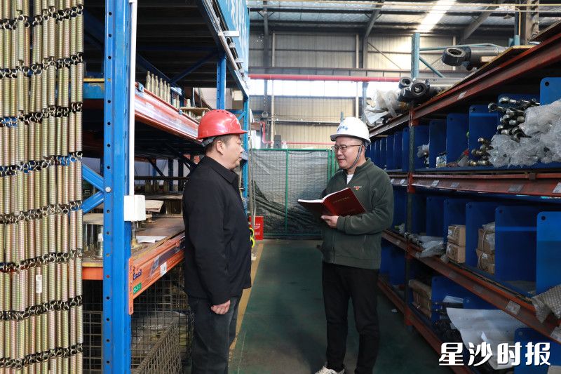 图为张力虎（右）在中小企业走访调研。周汝洁 摄