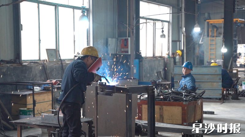 在企业生产车间,车间机器全开,工人赶进度如打仗。