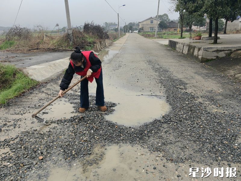 金井镇农裕村党员干部陈芳动手修补路面。均为通讯员供图