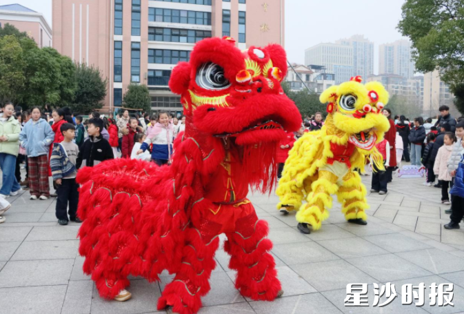 长沙市百熙实小校门前锣鼓喧天，两头精神抖擞的南狮踩着铿锵鼓点腾跃入场。