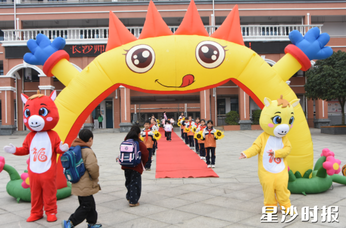 长沙师范学院附属春建小学师生走过拱门、踏上红毯，逐梦新程。