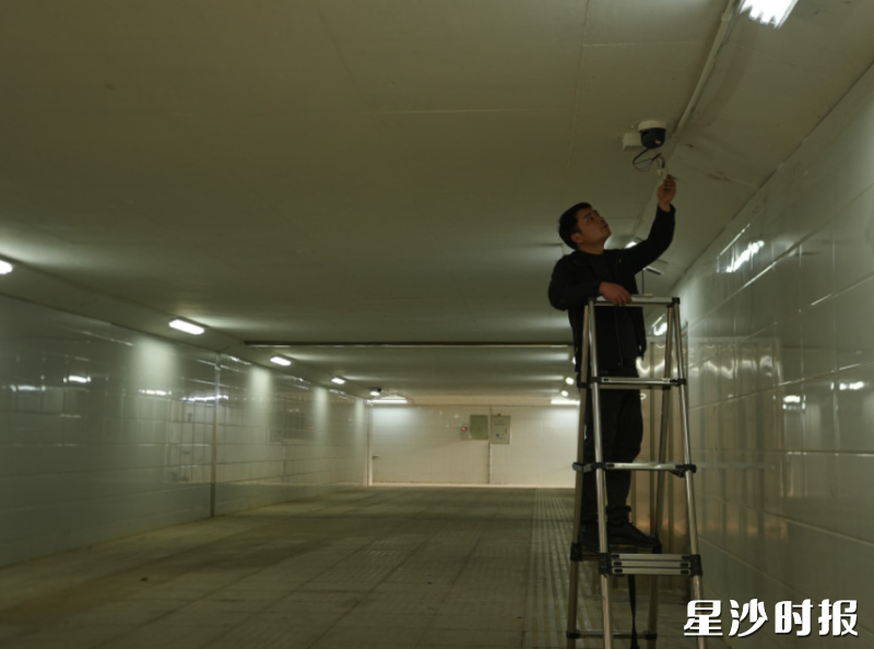 在宁华路与特立路交界处地下通道，工作人员细致检查摄像头电源、网络。