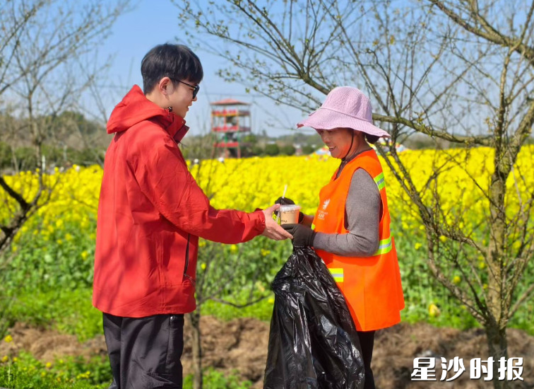 志愿者在现场为环卫工人送上一杯茶。杨源 摄