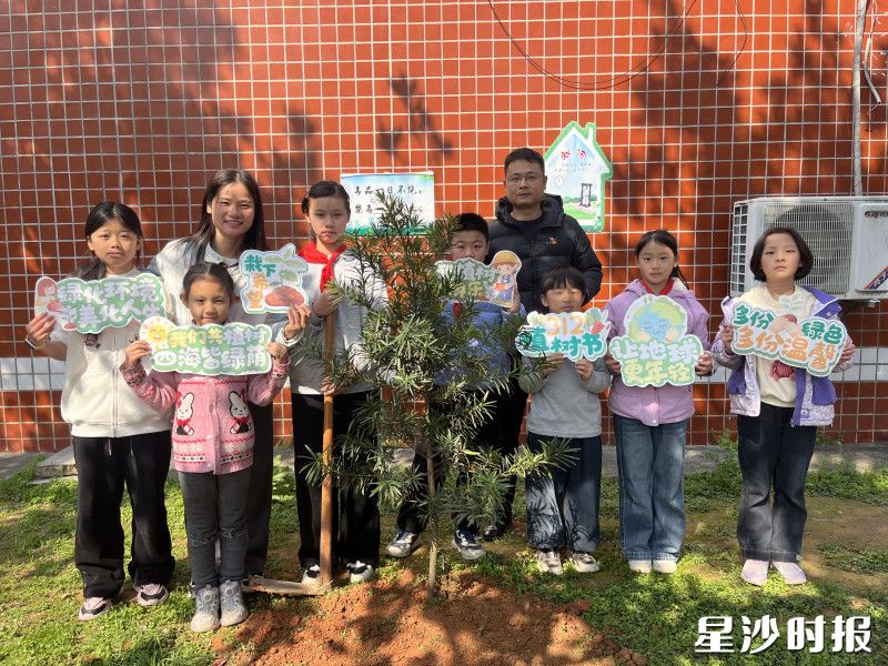 高桥镇维汉学校的孩子们在阳光下挥锹挖坑、扶苗填土、提水浇灌。
