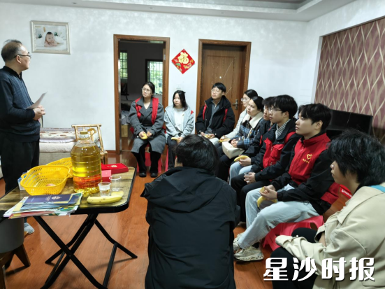 在中南汽车世界社区，大学生围坐在老党员身边，听他讲述入党初心的故事。