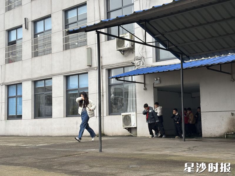 在学校教学楼开展紧急逃生消防演练现场。