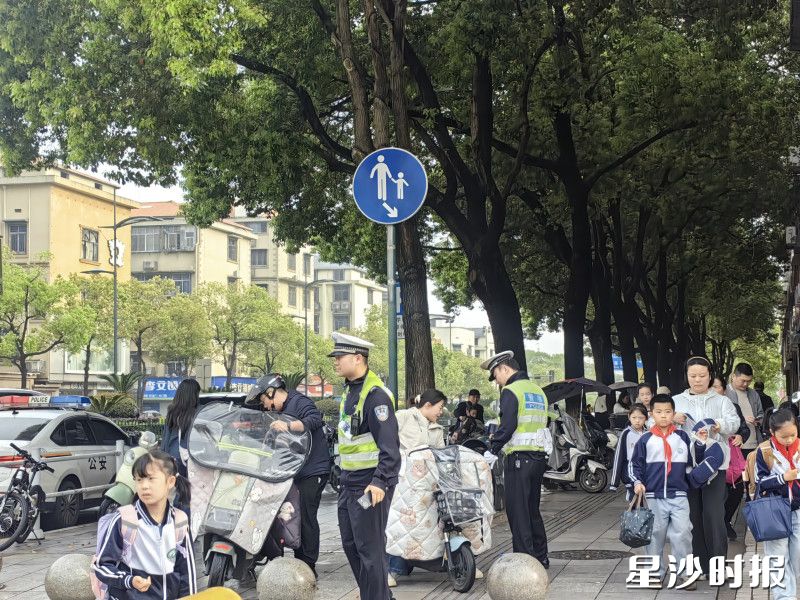 图为民警在叮嘱家长注意佩戴头盔。李丹 摄