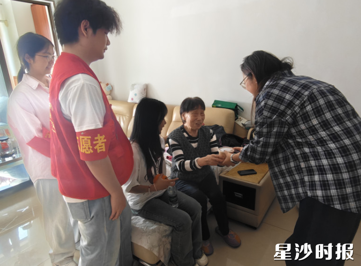 工作人员与志愿者上门为高龄老人送鸡蛋。星沙街道供图