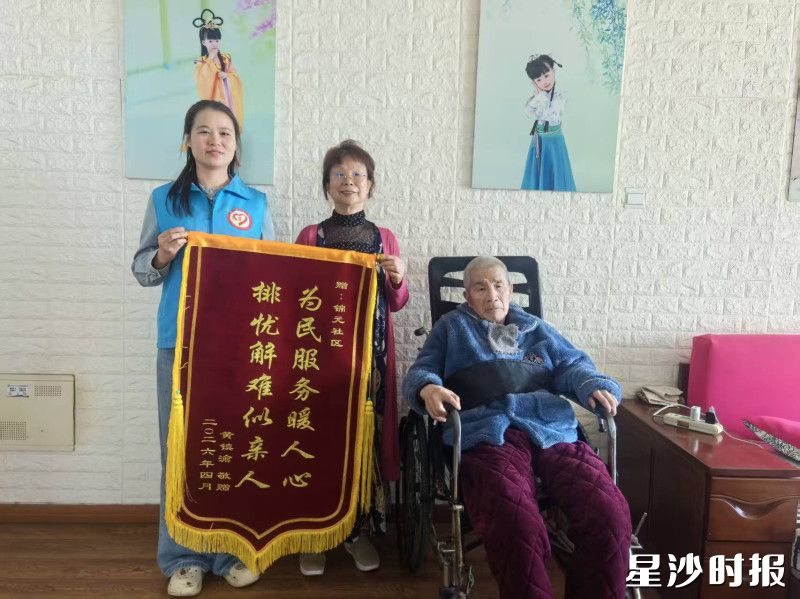 罗阿姨为社区工作人员送上锦旗。