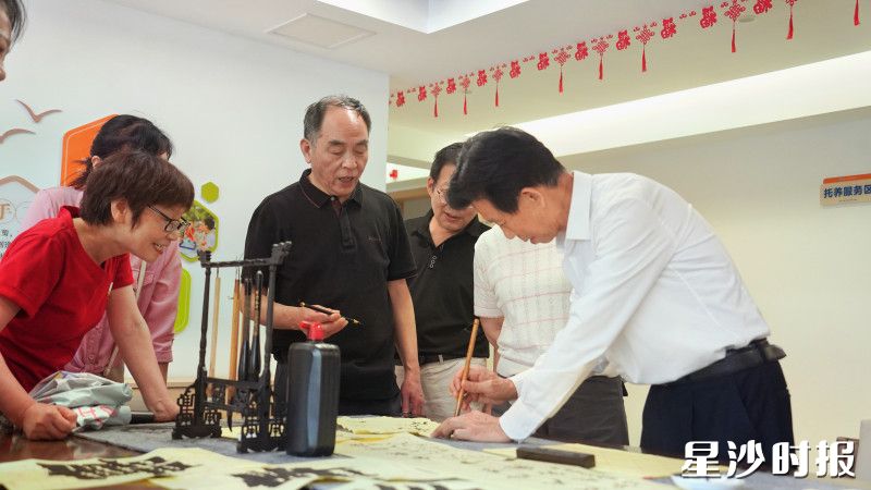 居民闲暇时在服务站体验书法课程。
