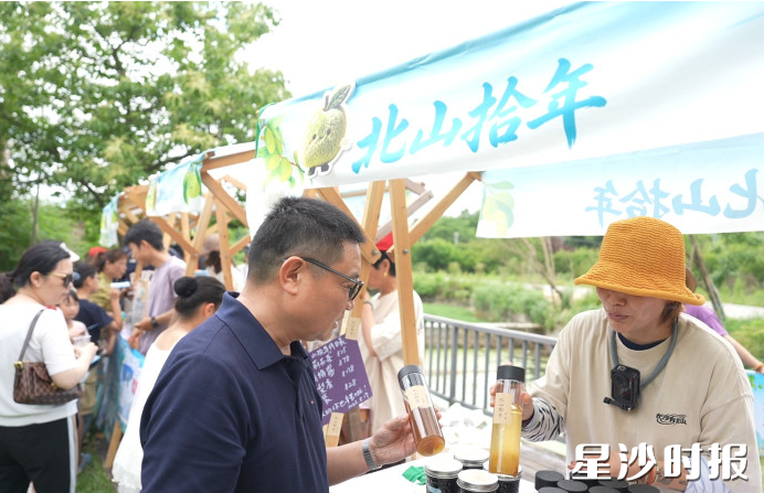 游客在摊位选购特色产品。 游客在摊位选购特色产品。