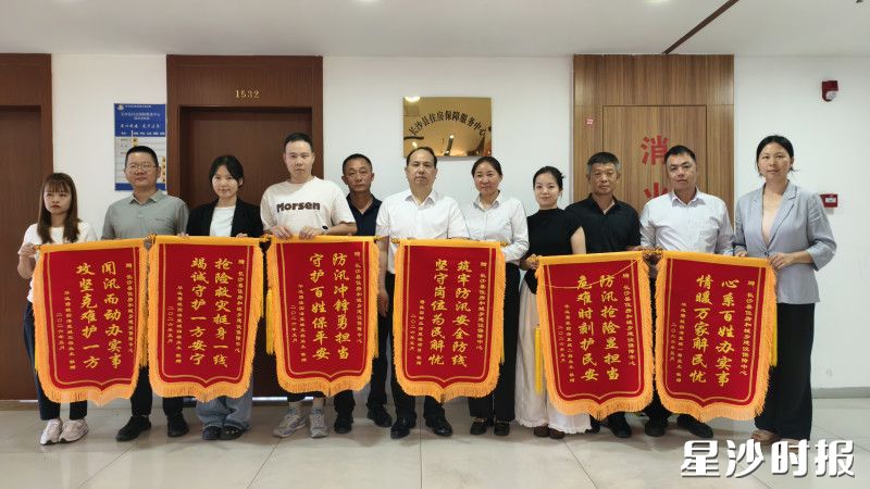 居民代表和物业工作人员送锦旗表示感谢。县住房城乡建设局供图