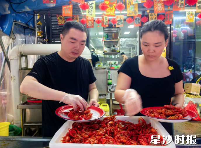 图为贺敏、成慧夫妇在门店忙碌。县文明办供图