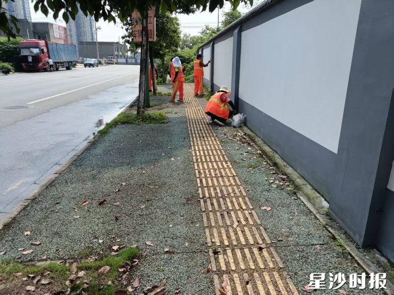 长沙市平高松雅湖中学周边，环卫工人在清理路面杂物。均为长沙县城管局供图