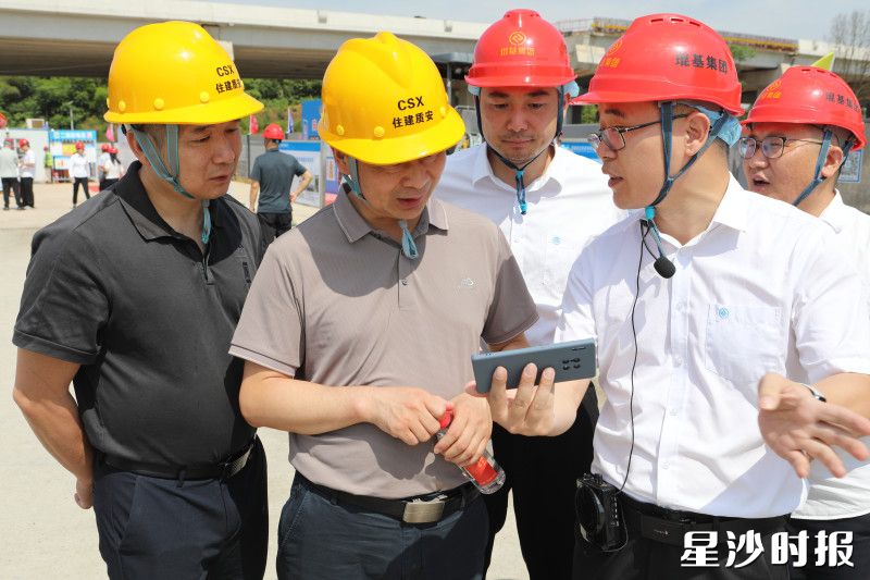 现场技术员演示讲解智能安全帽，云端读取人员定位、巡查轨迹、视频显示。县住房城乡建设局供图