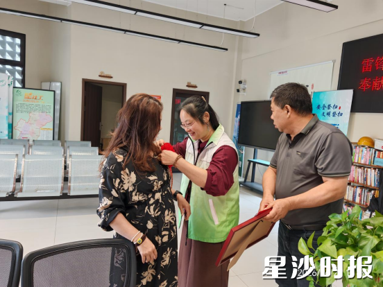社工为军人家属戴上大红花。 社工为军人家属戴上大红花。