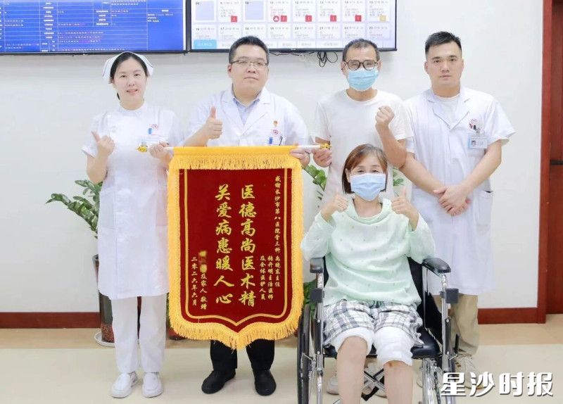 患者在出院前和医护人员进行合影，并赠送锦旗。