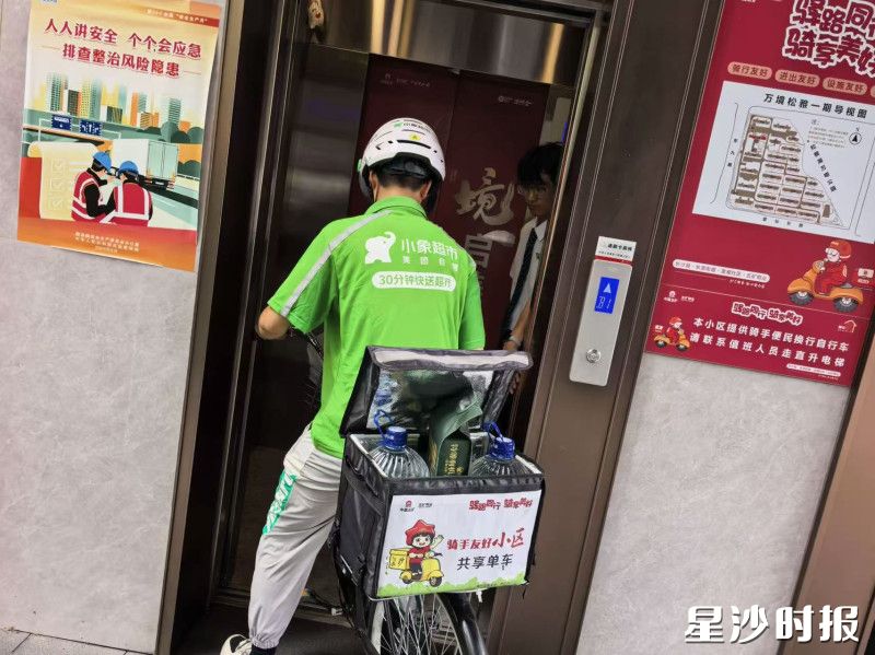 外卖骑手通过物业配置的转运自行车进电梯送外卖上门。均为县住房城乡建设局供图