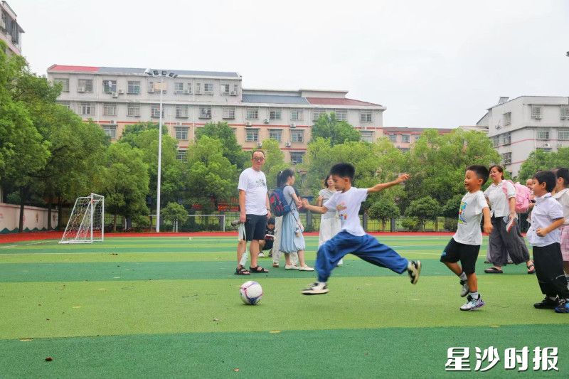 长沙市天华中学的操场上,小朋友抬腿射门,以运动活力开启新学期。