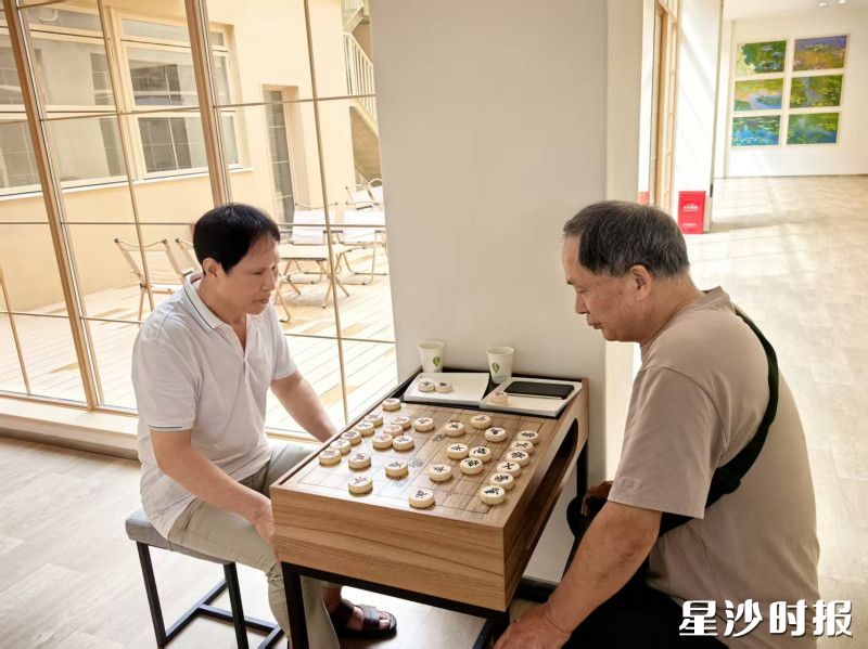 居民在“新家”下棋。