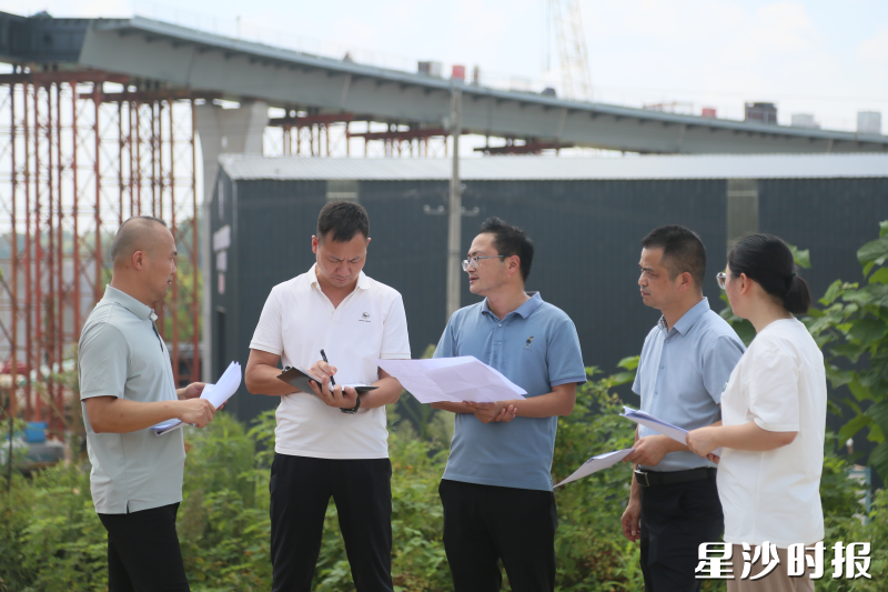 黄兴镇征拆专班在项目现场交流拆迁工作。