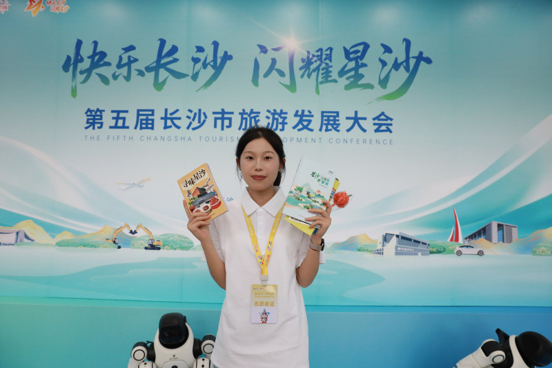 旅发大会现场,志愿者手握两本攻略书打卡拍照。均为宋彬彬 摄 旅发大会现场,志愿者手握两本攻略书打卡拍照。均为宋彬彬 摄