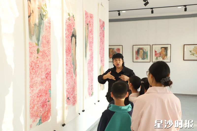 吴振明正为孩子们讲解馆内的书画作品。阮霖浩 摄