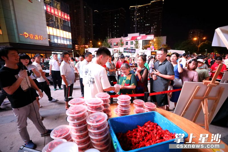 万象汇夜间市集上，一餐馆老板现场制作200余份口味虾给市民免费品尝。 盛磊 摄