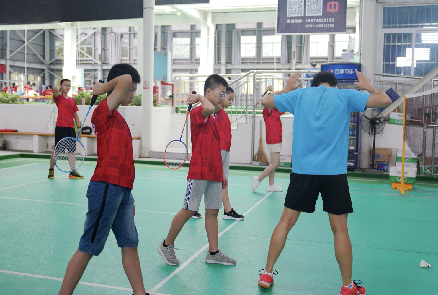 在板仓路老年人活动中心羽毛球培训场,孩子们在老师指导下纠正动作.