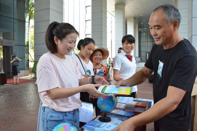 活动现场,工作人员在进行发放宣传资料.均为 李生辉 摄