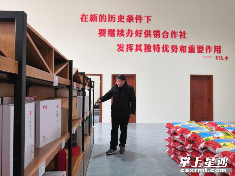 林金良看着湘丰村供销合作社货架上的产品，思考着合作社的未来发展。吴涛 摄