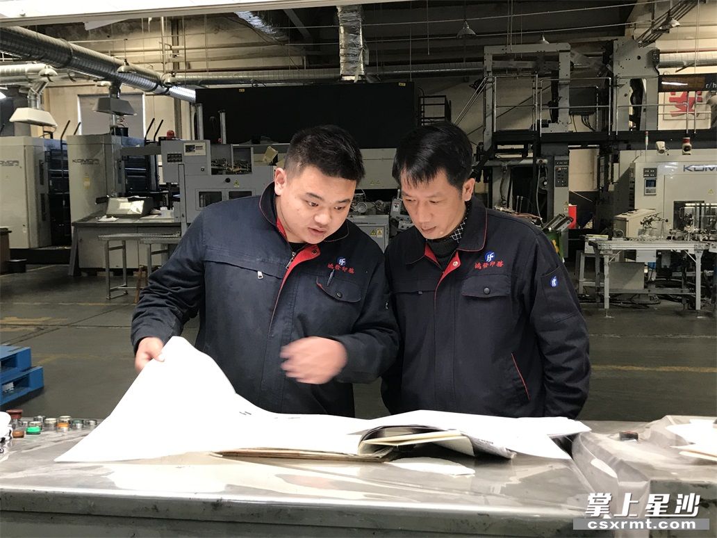 鸿发印务实业有限公司印刷生产车间，员工正在对印刷产品抽样检查。均为 尹理 摄