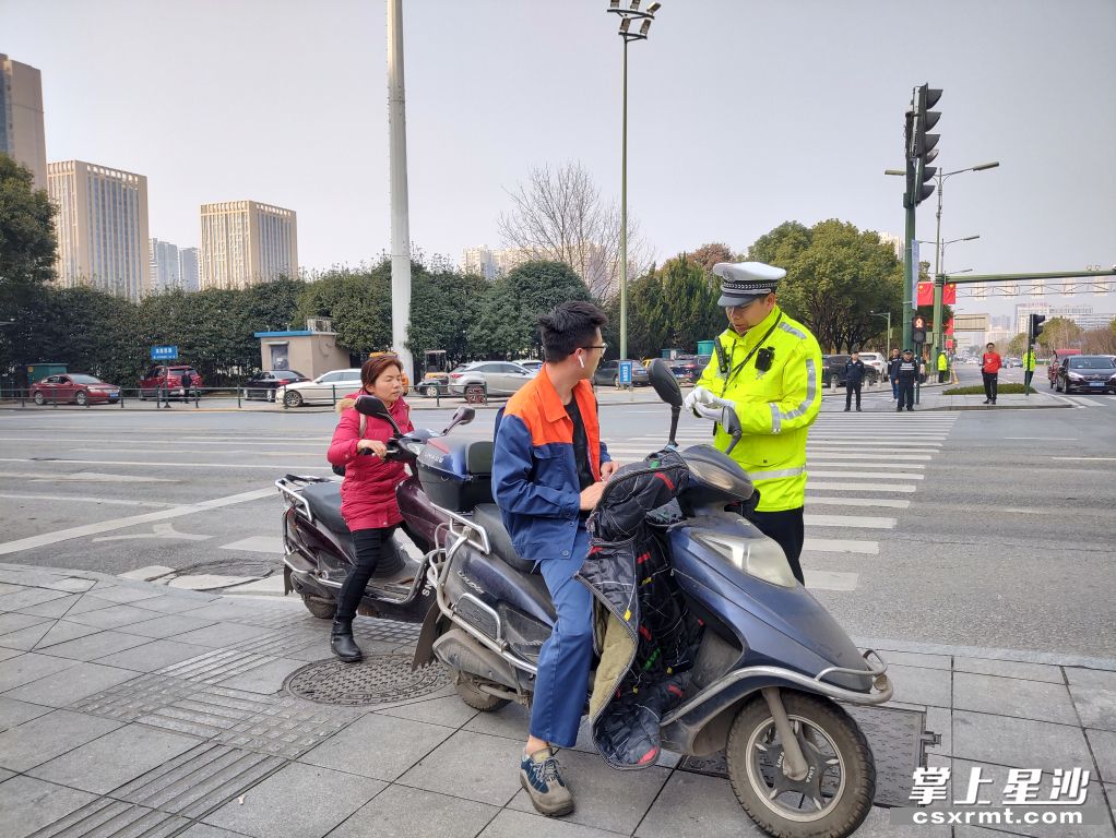2月22日,星沙大道漓湘路口,交警拦截下两名未戴头盔的电动车驾乘人.