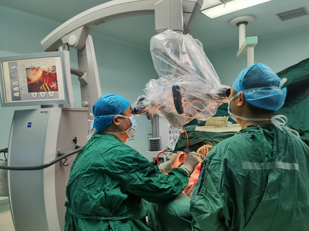 长沙市中医医院神经外科主任段继新带领团队在显微镜下为病人进行颅脑