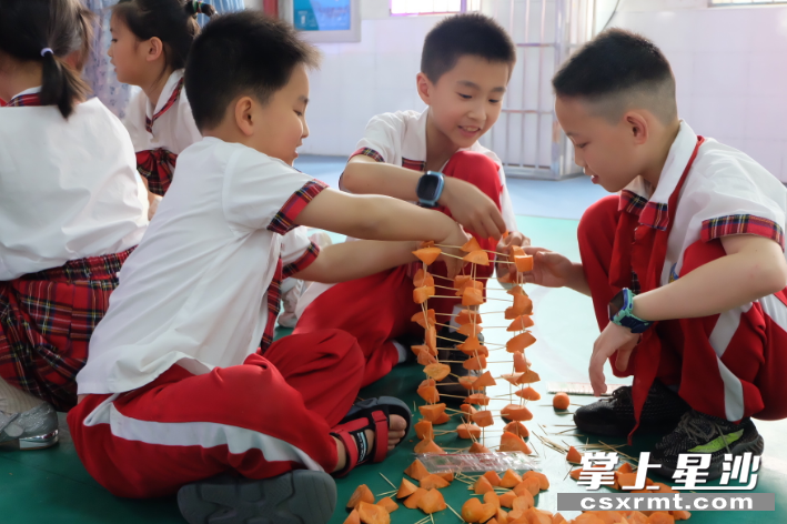 孩子们在用胡萝卜和牙签搭建高塔。李丹 摄