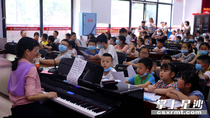 图为易小雯老师教小区儿童唱红歌。 盛磊 摄 图为易小雯老师教小区儿童唱红歌。 盛磊 摄