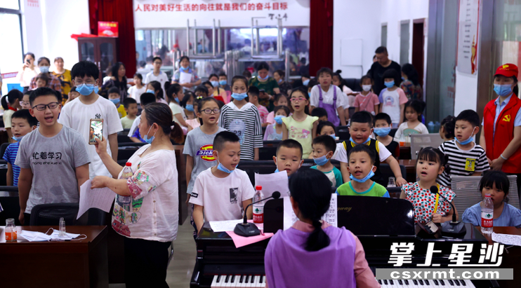 图为易小雯老师教小区儿童唱红歌。 盛磊 摄 图为易小雯老师教小区儿童唱红歌。 盛磊 摄