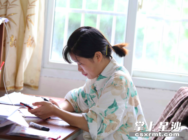 佘曼妮在办公室一个个登记安全到家的学生。