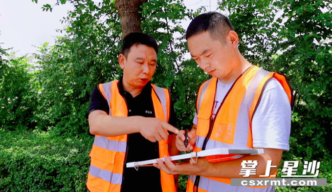 青山铺中队记录路面隐患。曾媚 摄