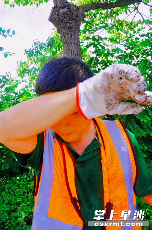 青山铺中队队员路面作业间隙擦汗休息。吴婉沁 摄